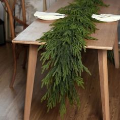 the table is set with pine branches and plates