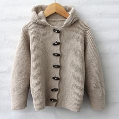 a sweater with buttons is hanging on a hanger