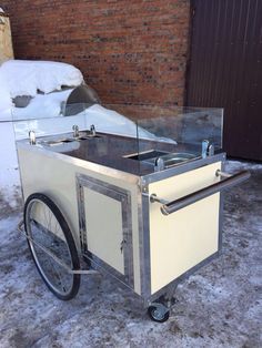 an ice cream cart sitting on top of snow covered ground