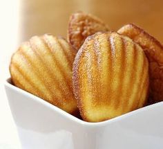 a white bowl filled with sugar covered donuts