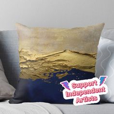 a gold and blue throw pillow with the words support independent artists in pink lettering on it