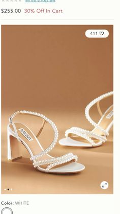 a pair of women's shoes with pearls on the heel and heels in white