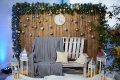 a wooden bench sitting next to a wall covered in christmas decorations and lights with a blanket draped over it