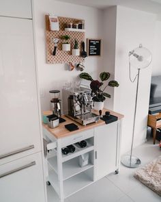 a kitchen with white cabinets and wooden counter top next to a wall mounted coffee maker