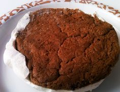 a chocolate cake sitting on top of a white plate with a brown and orange border