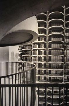 black and white photograph of buildings with balconies in the foreground, taken from an upper level balcony