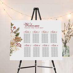 a welcome sign on a easel in front of a christmas tree with lights and garlands