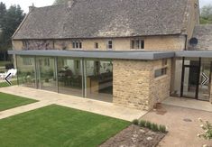 an outside view of a house that has grass in the front yard and patio area