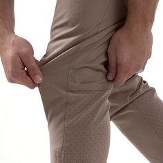 a close up of a person's pants with their hands on the pocket and one hand in his pocket