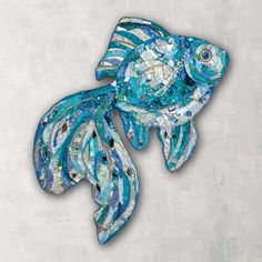 a fish made out of glass sitting on top of a wall