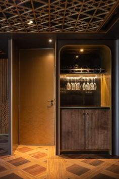 a room with wooden floors and a wine rack in the center, surrounded by glass doors