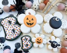 decorated cookies and decorations for halloween on a table with black and white polka dotes