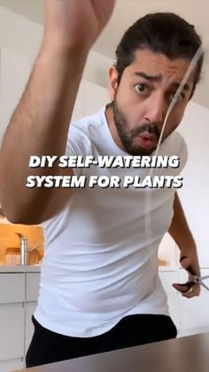 a man holding a knife in front of his face with the words diy self - watering system for plants