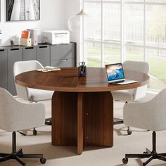 a round table with four chairs around it and a laptop computer on the top, in an office setting