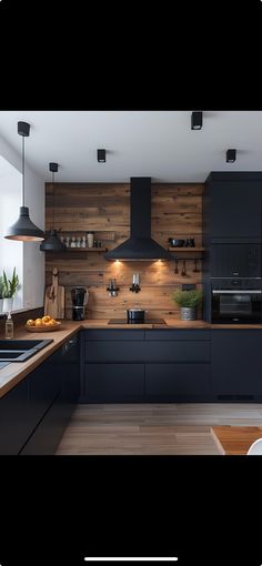 an image of a modern kitchen setting with black cabinets and wood paneling on the wall