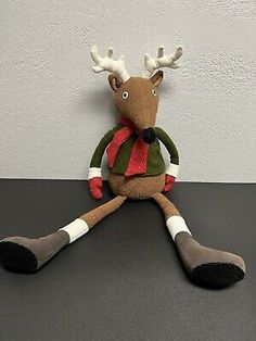 a stuffed reindeer sitting on top of a black table next to a white and gray wall