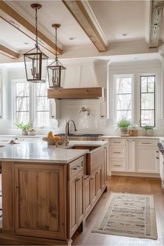 a large kitchen with white cabinets and wooden flooring, along with an island in the middle