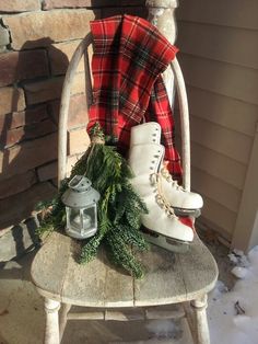 a pair of ice skates sitting on top of a wooden bench next to a lantern