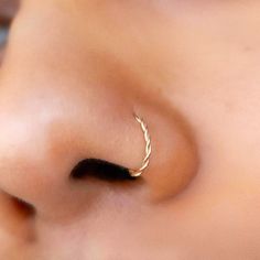 a close up of a person's nose with a gold nose ring on it