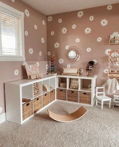 a child's room with pink walls and white furniture