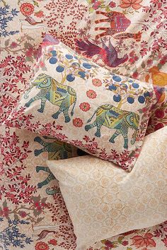 three pillows stacked on top of each other with elephants and flowers all over the pillow