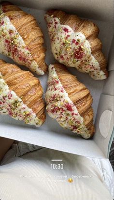 four croissants with different toppings in a box