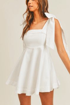 This bestselling style is now back in stock! The Walking Down the Aisle White Mini Dress is the 2022 "it girl dress" in bridal style. Perfect for your bridal shower or a daytime bachelorette event, this simple white mini dress's showstopping element is its oversized bow tie shoulders. Hits mid-thigh, but its adjustable shoulder ties give you the opportunity to make the dress a little shorter or longer. It Girl Dress, White Dresses Graduation, Dress Stands, Tie Ribbon, Bow Tie Dress, Ribbon Dress, Fit And Flare Skirt, White Short Dress, Sun Valley