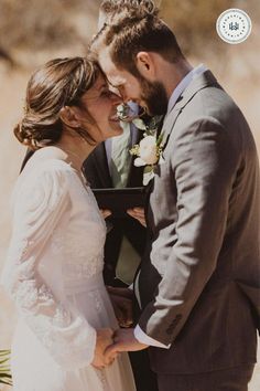 a bride and groom standing close to each other in front of a desert background with text overlay