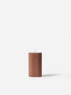 a brown candle sitting on top of a white table