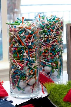 two clear vases filled with different colored sprinkles next to each other