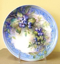 a blue and white plate sitting on top of a table next to a yellow wall