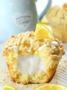 lemon muffins with cream cheese filling are on a plate next to some lemon slices