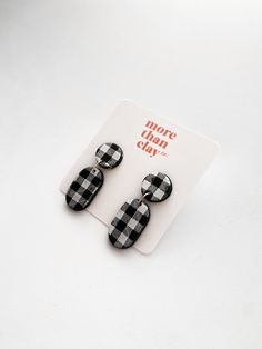 two black and white checkered earrings on top of a card with the words more plaid day