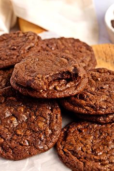 a pile of chocolate cookies sitting on top of a white plate