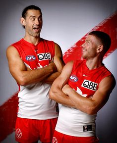 two men in red and white uniforms are posing for a photo with their arms crossed