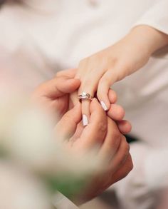 two people holding hands with wedding rings on their fingers