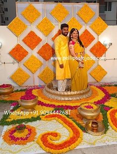 a man and woman standing in front of a flower arrangement