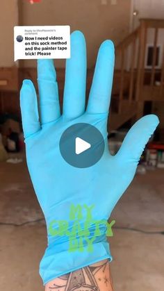 a person wearing blue gloves holding up their hand