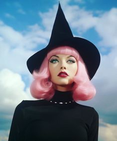 a woman with pink hair wearing a black hat