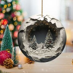 a christmas ornament hanging on a table next to a christmas tree and other decorations