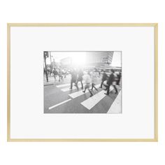 a black and white photo of people crossing the street in front of a crosswalk