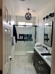 a white and black bathroom with double sinks