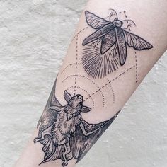 a person with a tattoo on their arm has a dragon flying over the bat and insect