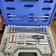 a tool set in a blue case on top of a table with wrenches and other tools