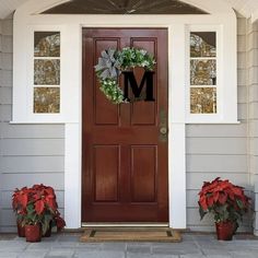 the front door is decorated with poinsettis and greenery