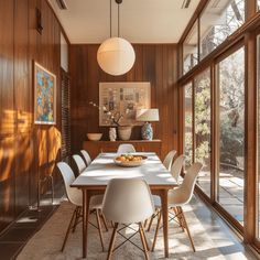 a dining room with wood paneling and white chairs