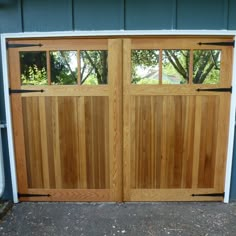 two wooden garage doors with windows on each side