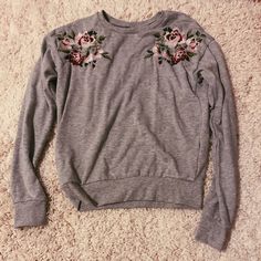 Grey Crewneck !! Has Flowers Embroidered On Each Side And Bought In Europe. Never Worn Before And In Great Condition ! Spring Floral Embroidered Crew Neck Sweatshirt, Cute Floral Embroidered Long Sleeve Tops, Casual Tops With Floral Applique, Cute Floral Embroidery Fall Tops, Spring Long Sleeve Sweatshirt With Floral Embroidery, Pink Cotton Sweatshirt With Floral Embroidery, Casual Crew Neck Top With Embroidered Hem, Spring Long Sleeve Tops With Embroidered Graphics, Spring Floral Embroidery Long Sleeve Sweatshirt