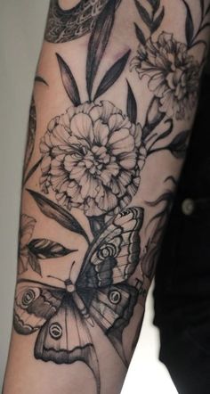 a woman's arm with flowers and butterflies on it