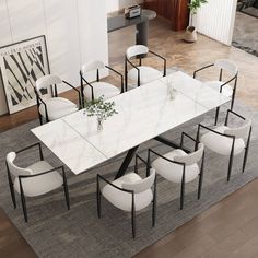 a dining table with white chairs around it